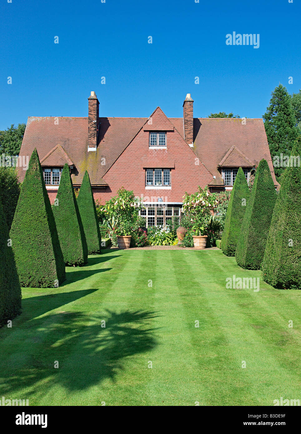 HOUSE  AND LAWNED GARDEN WITH TOPIARY AT VICARAGE GARDEN EAST RUSTON NORFOLK ENGLAND UK Stock Photo