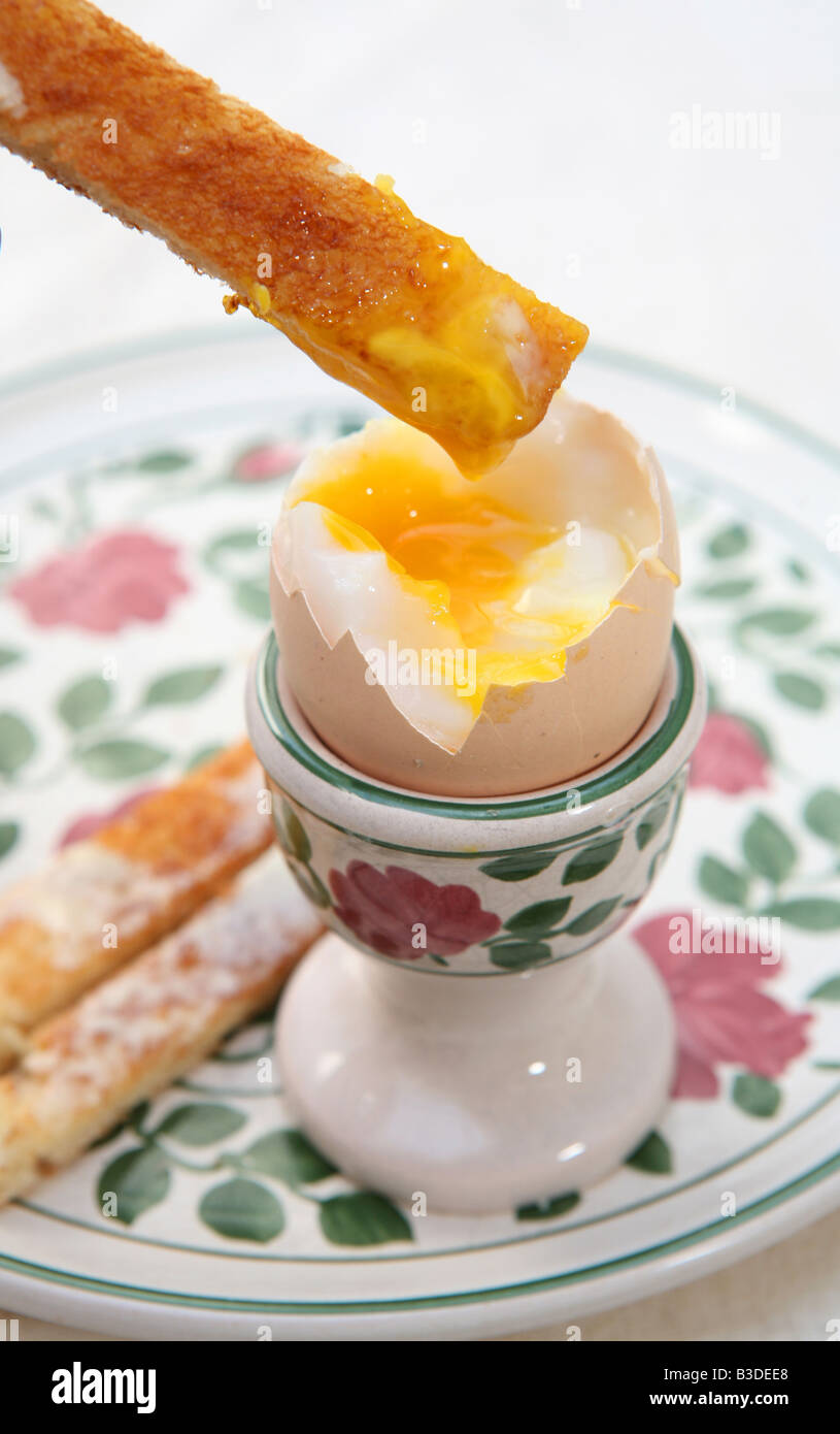 Dipping a buttered toast soldier into a soft boiled egg A British