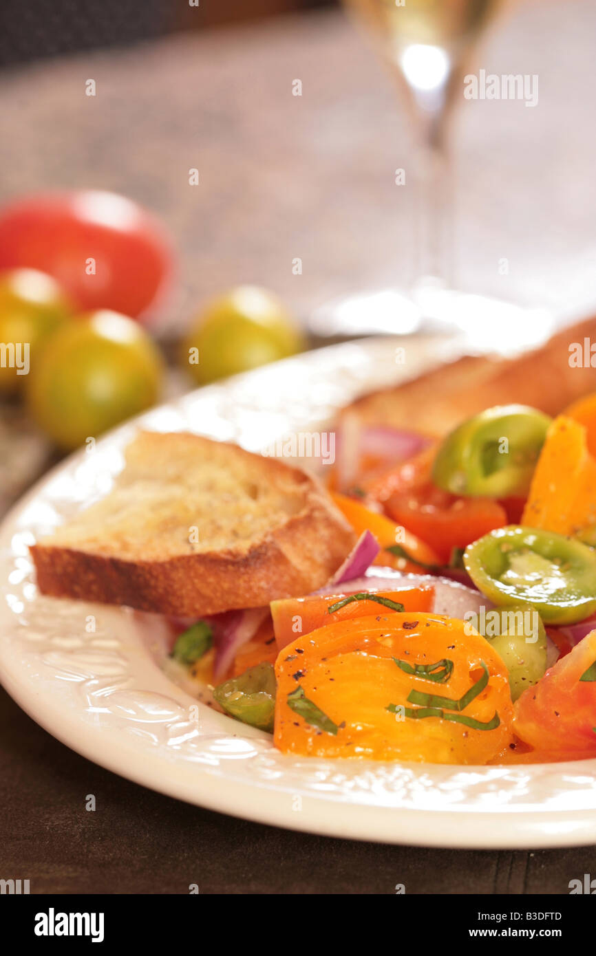 Colorful and Bright Tomato and Onion Salad With a Slice of Bread Stock Photo