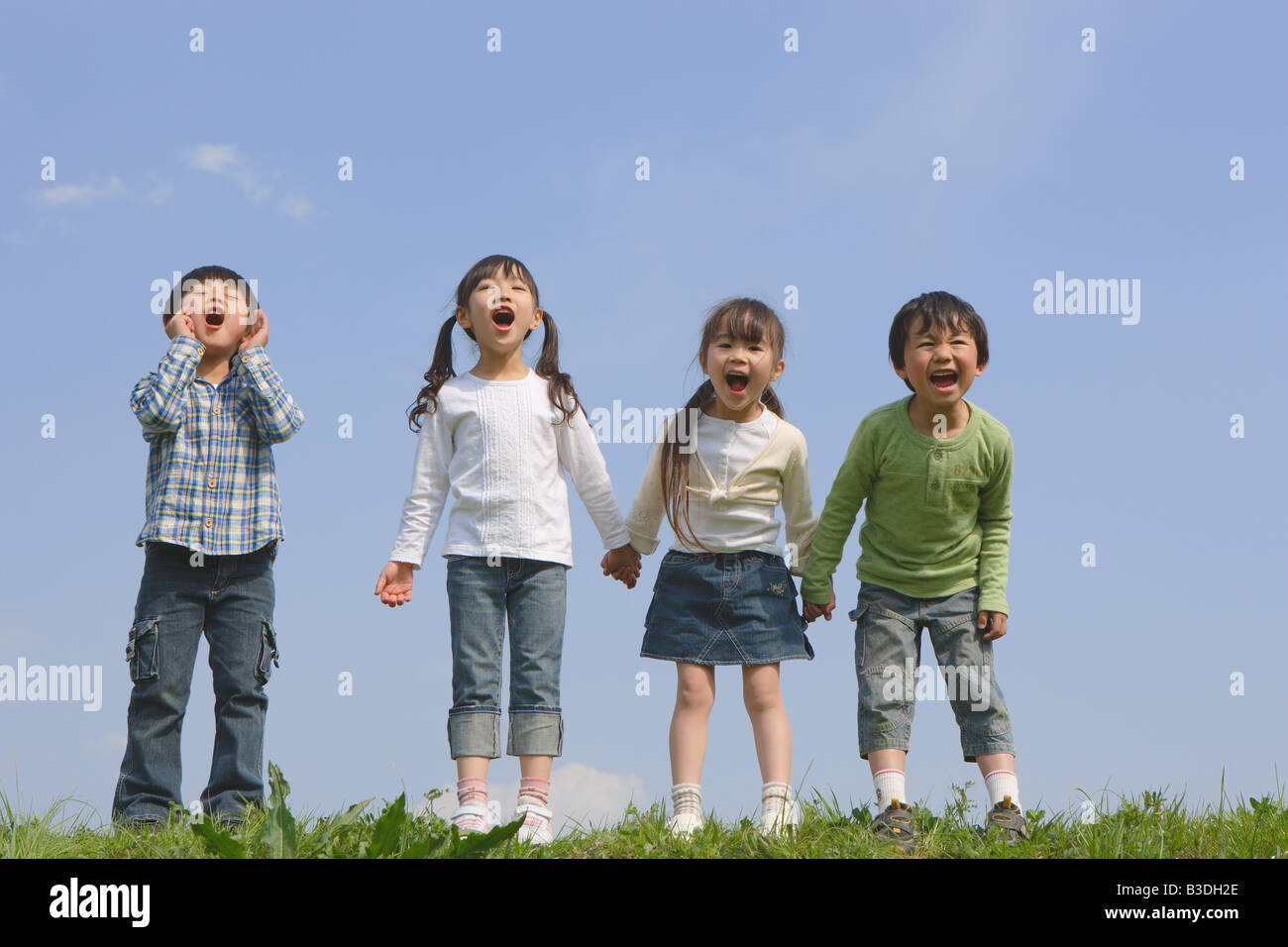 Children standing in a row and yelling together Stock Photo
