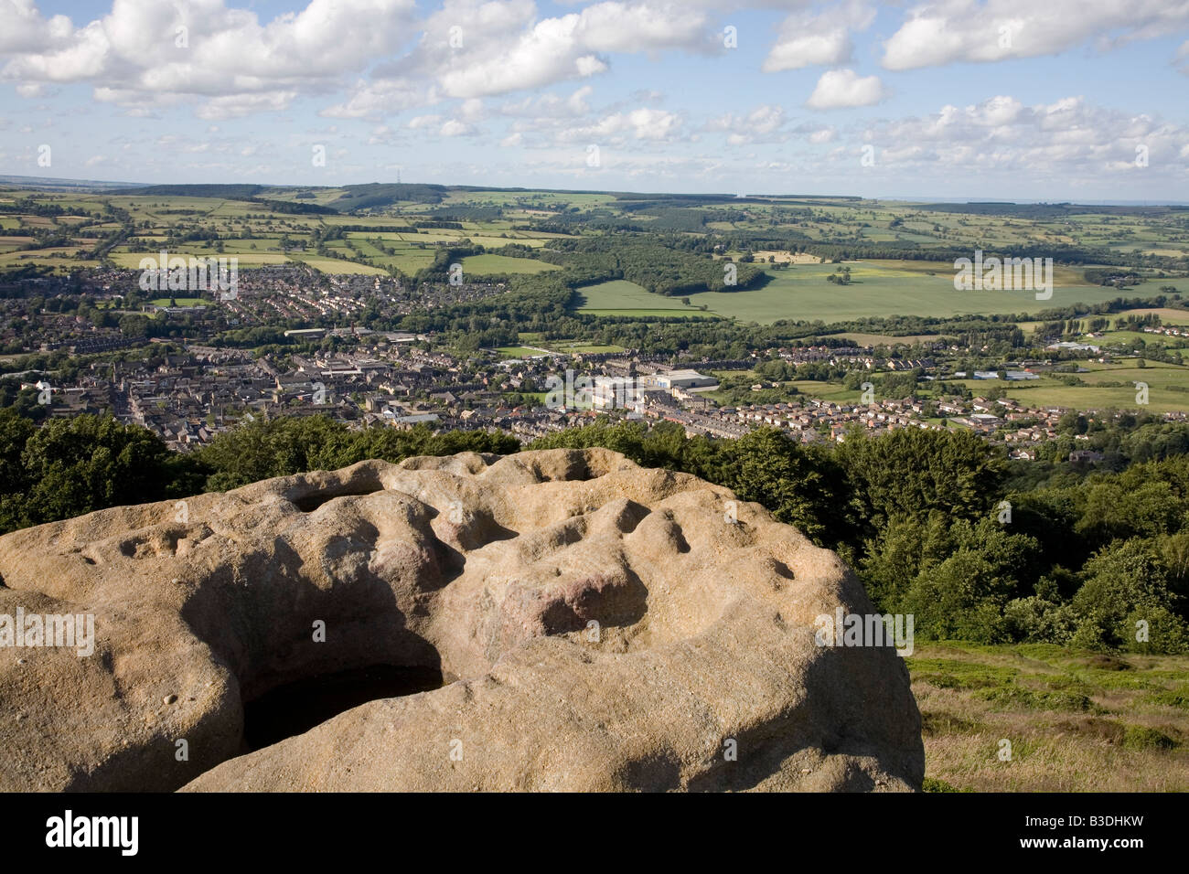 Weathered boulder on the Chevin with Otley in the distance, near Leeds West Yorkshire UK June 2008 Stock Photo