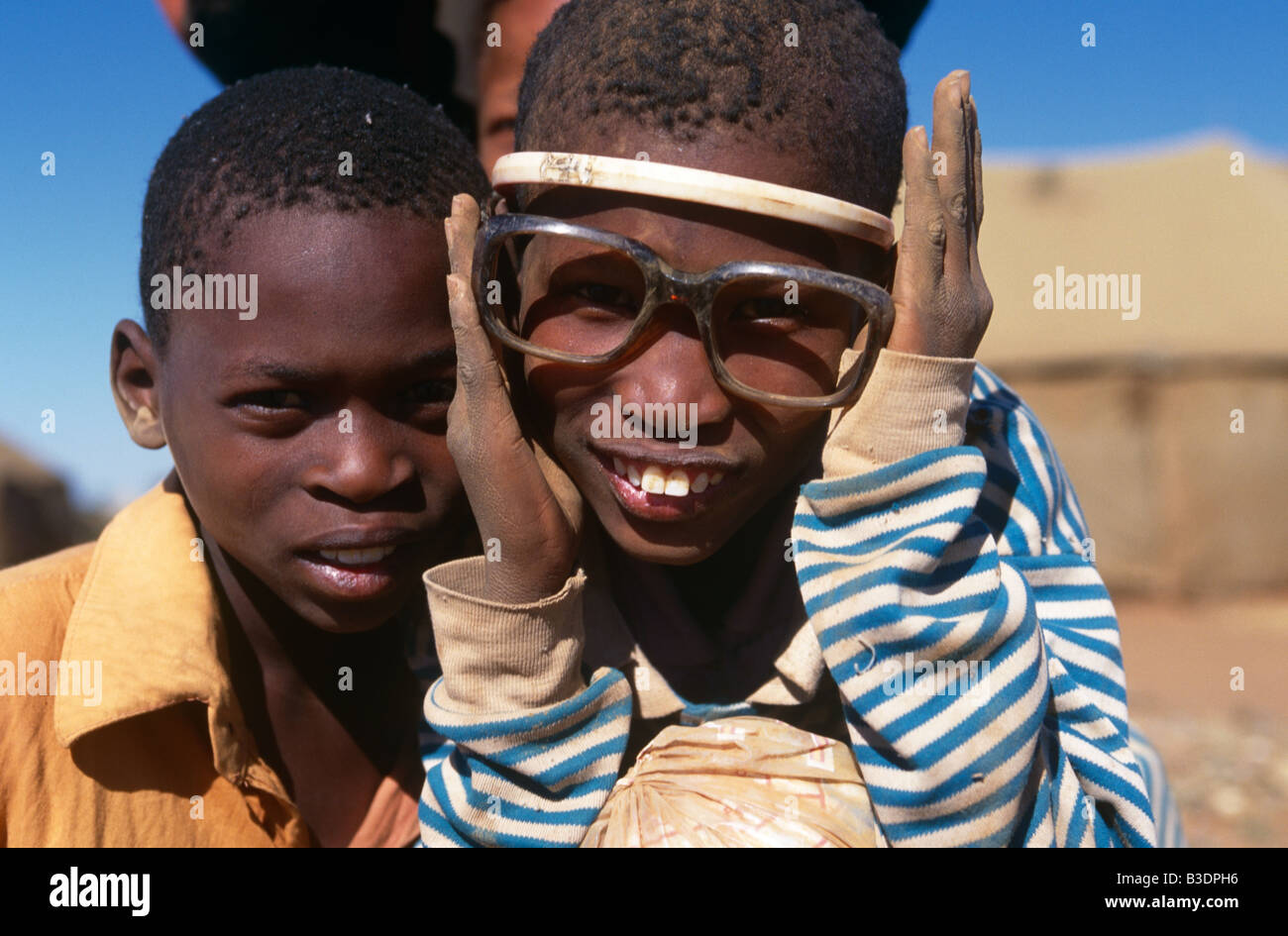 Two boys posing in muddy spectacle frames, close up portrait, south