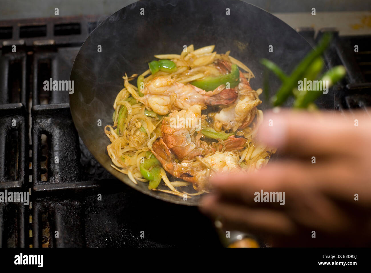 A chef cooks prawns in an Indian restaurant Stock Photo