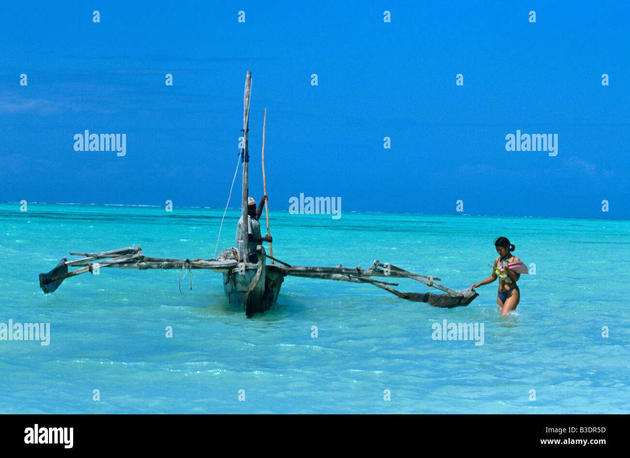 Small boat floating on clear blue sea, Zanzibar Stock Photo Alamy