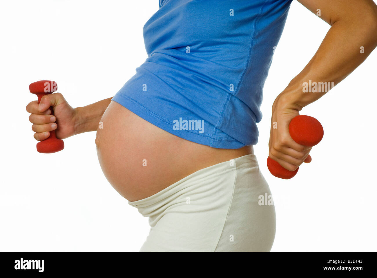 PREGNANT WOMAN EXERCISING WITH DUMB BELLS Stock Photo