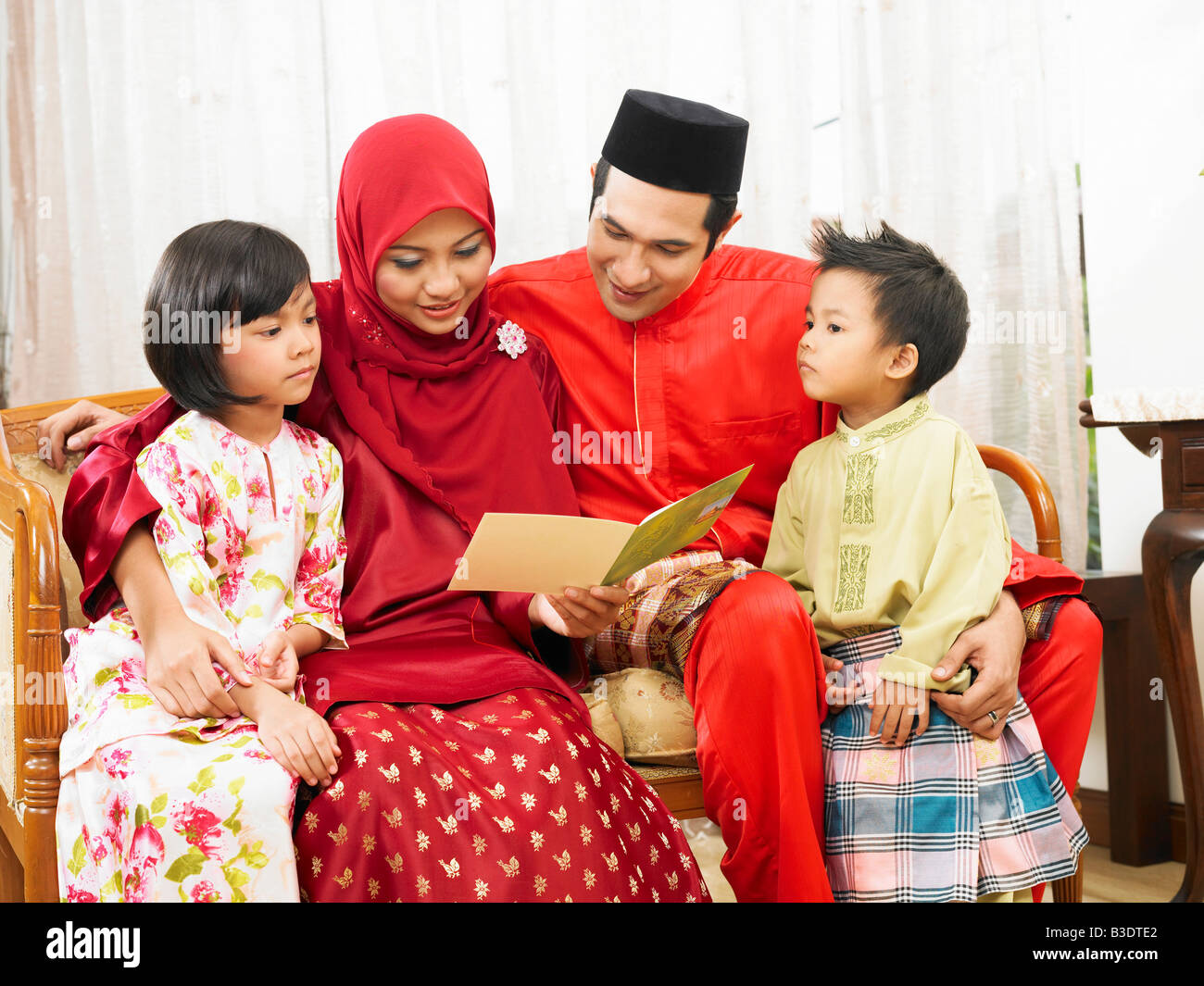 Family reading greeting card laughing together Stock Photo