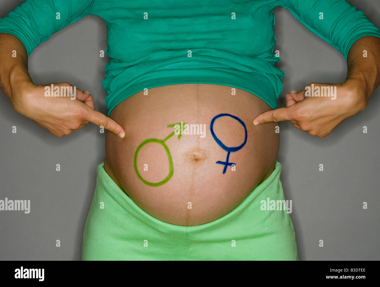 PREGNANT WOMAN PAINTED ON BELLY Stock Photo