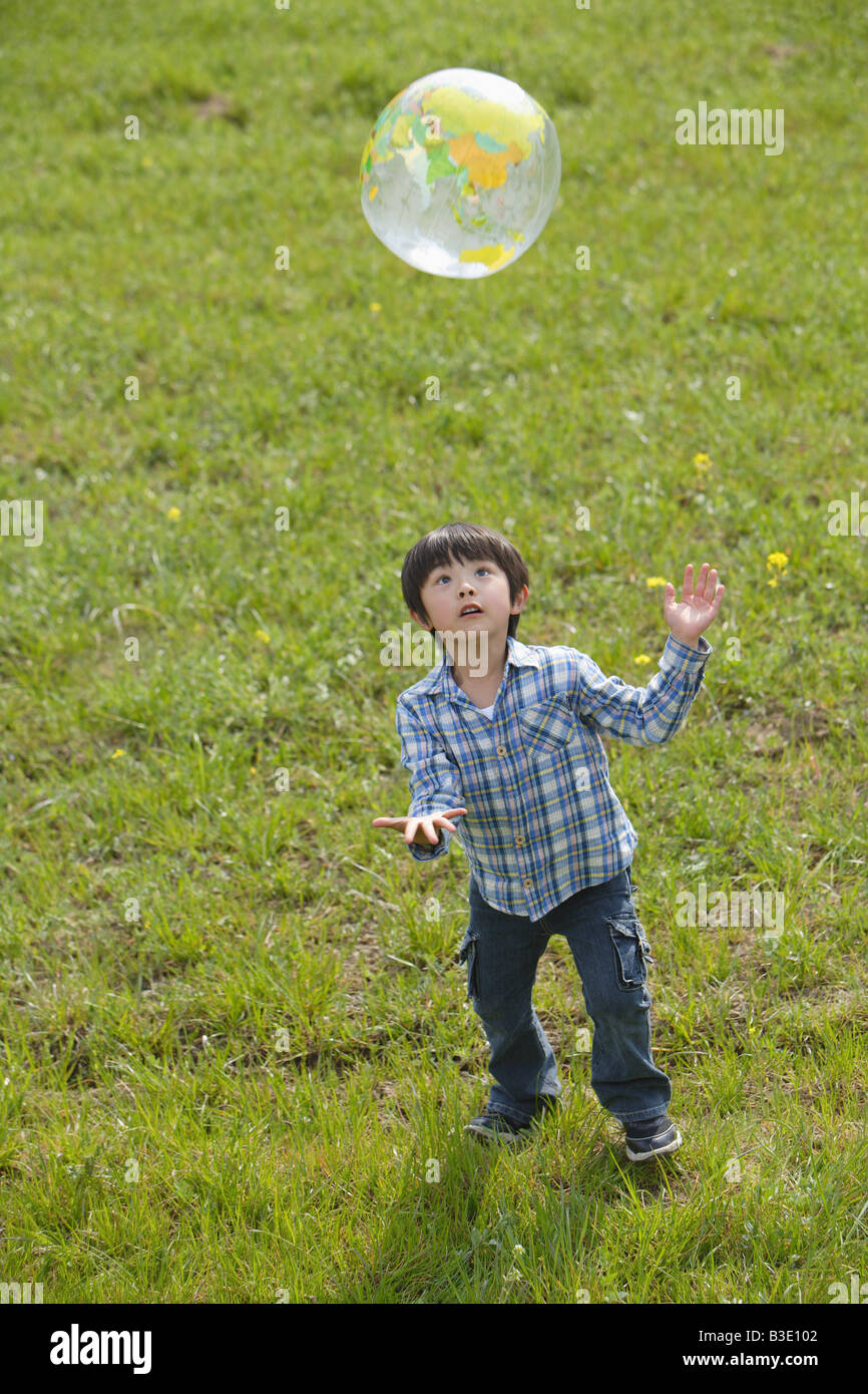 Boy playing with a ball in park Stock Photo - Alamy