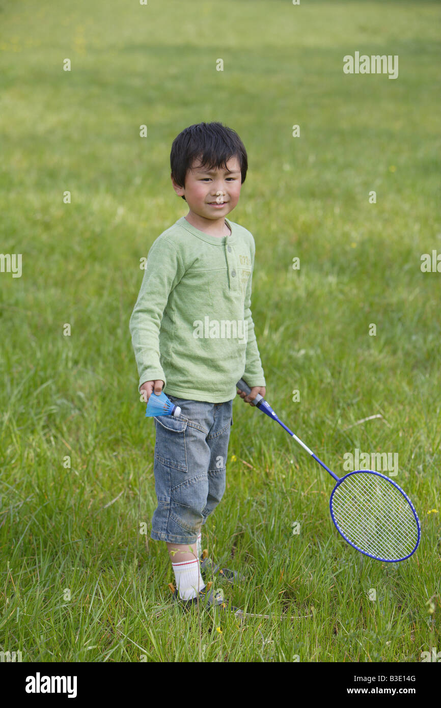 Boy playing badminton in park Stock Photo