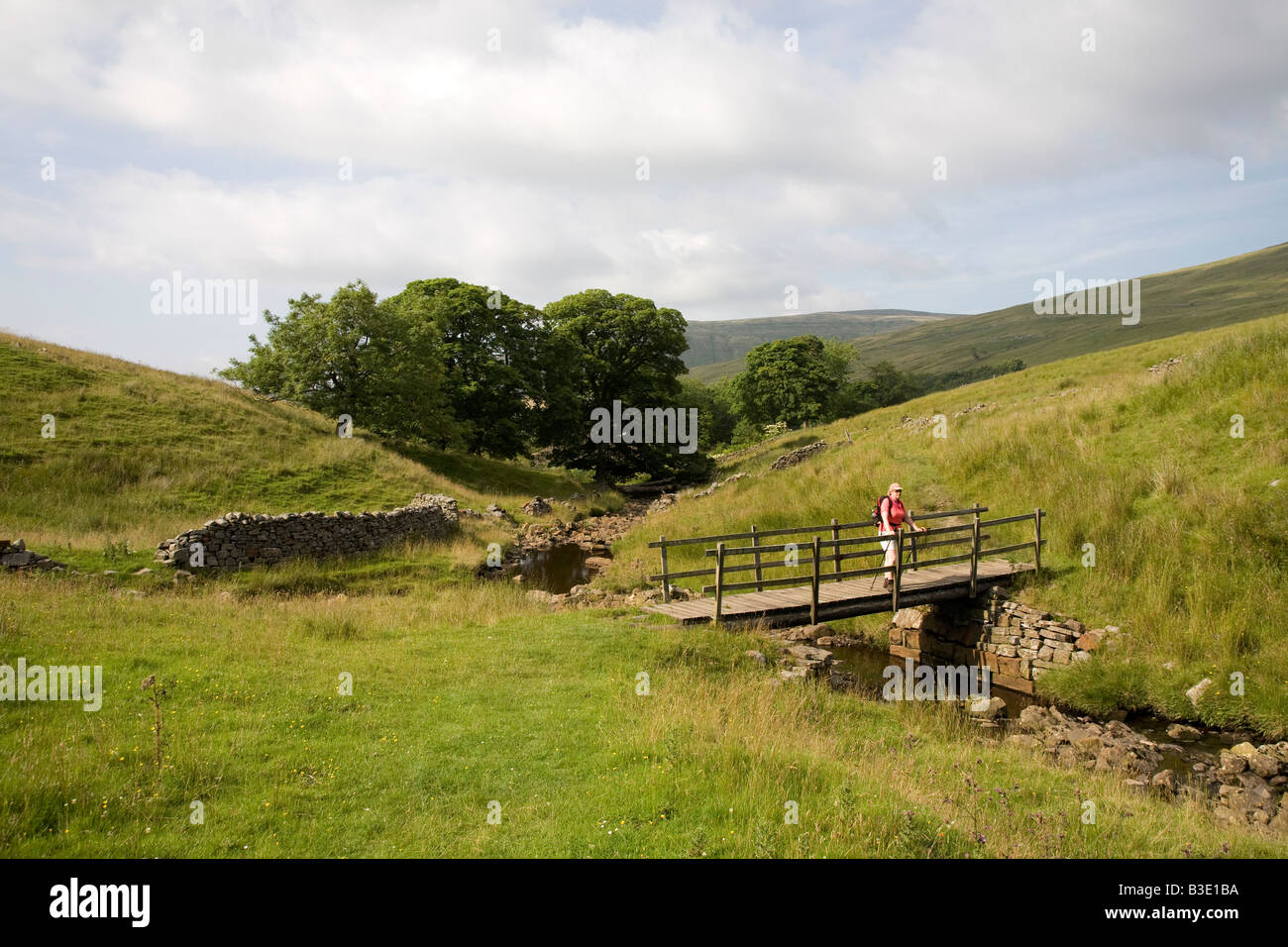 A walker resting on a bridge in the Ribblehead, Dent area of the Yorkshire Dales UK July 2008 Stock Photo