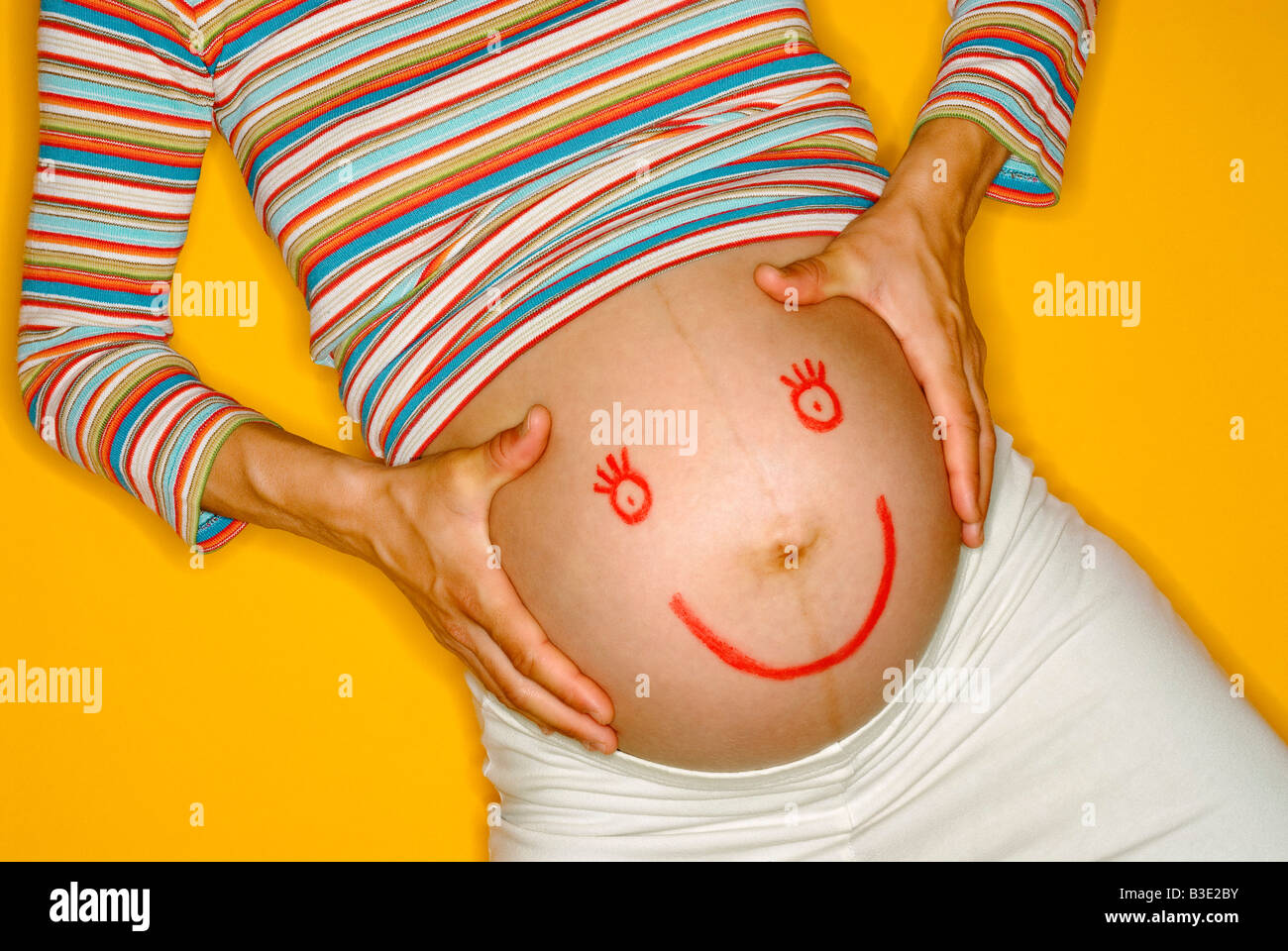PREGNANT WOMAN PAINTED ON BELLY Stock Photo
