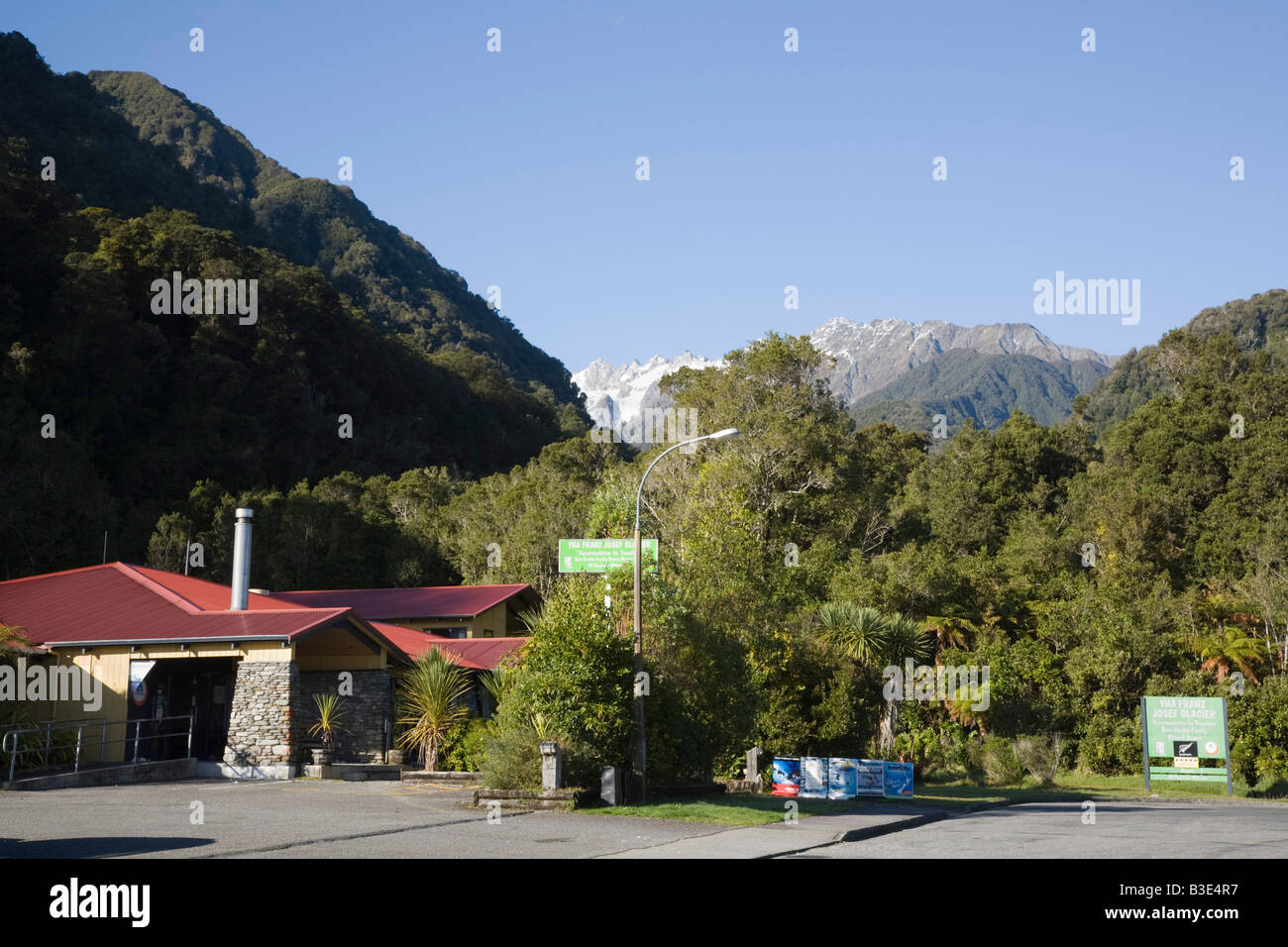 Franz Josef South Island New Zealand YHA Franz Joseph Glacier youth hostel  in wooden building with mountains beyond Stock Photo - Alamy