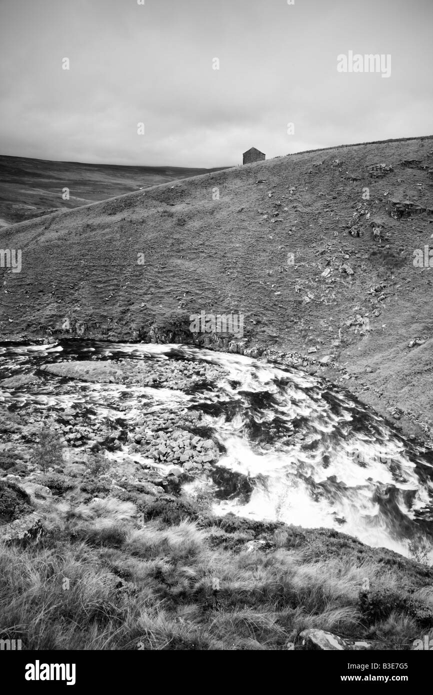 The River Tees in spate flows past a remote barn in Upper Teesdale