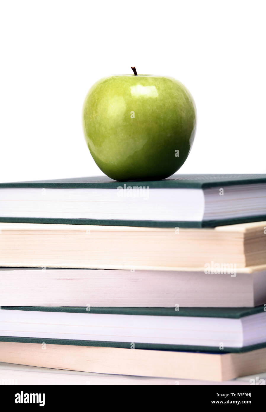 An apple on top of a pile of books white background Stock Photo Alamy