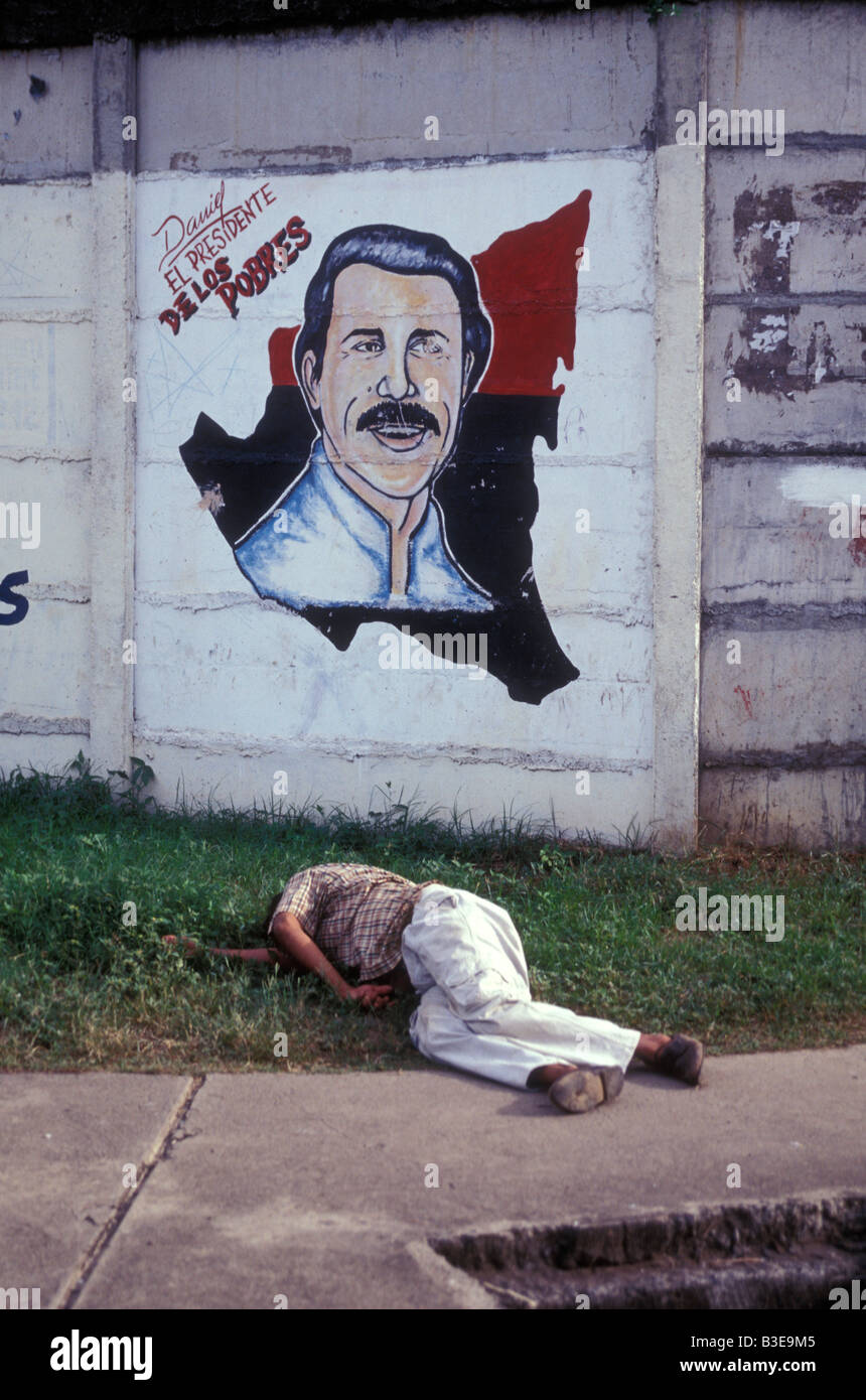 Drunken man sleeping in front of a Sandinista political painting depicting Daniel Ortega 1998, Managua, Nicaragua Stock Photo