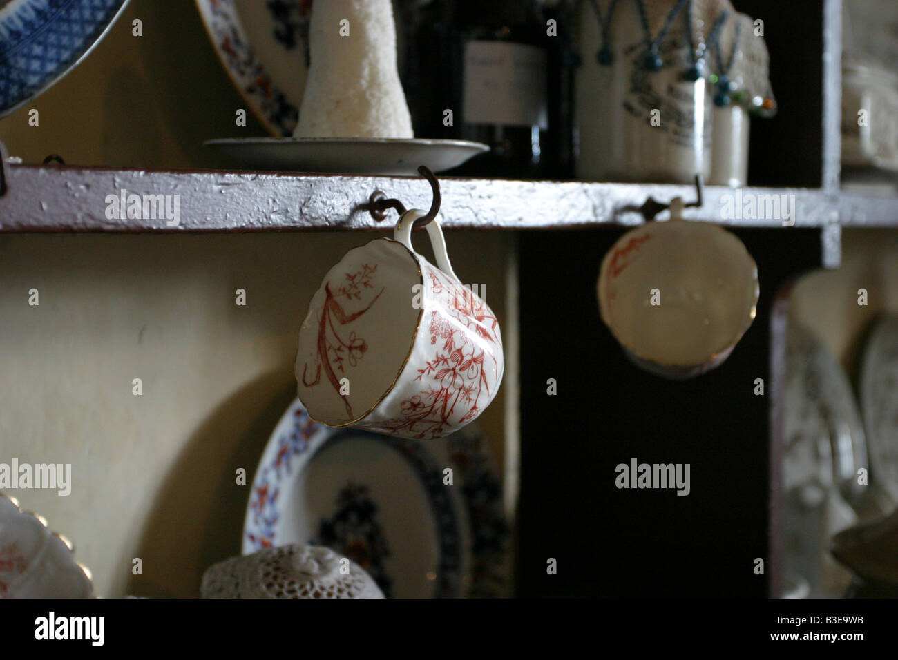 tea cups hanging on a traditional kitchen dresser Stock Photo