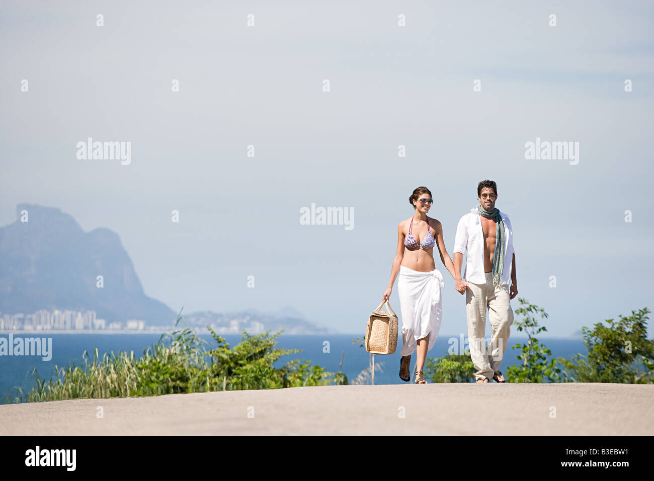 Young couple walking hand in hand Stock Photo - Alamy