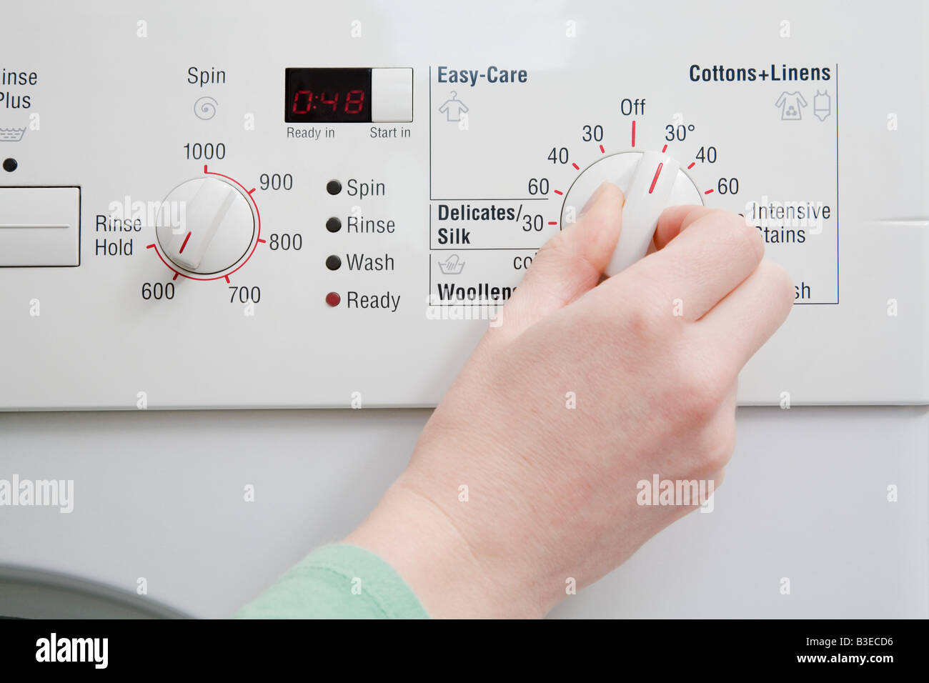 Person turning dial on washing machine Stock Photo Alamy