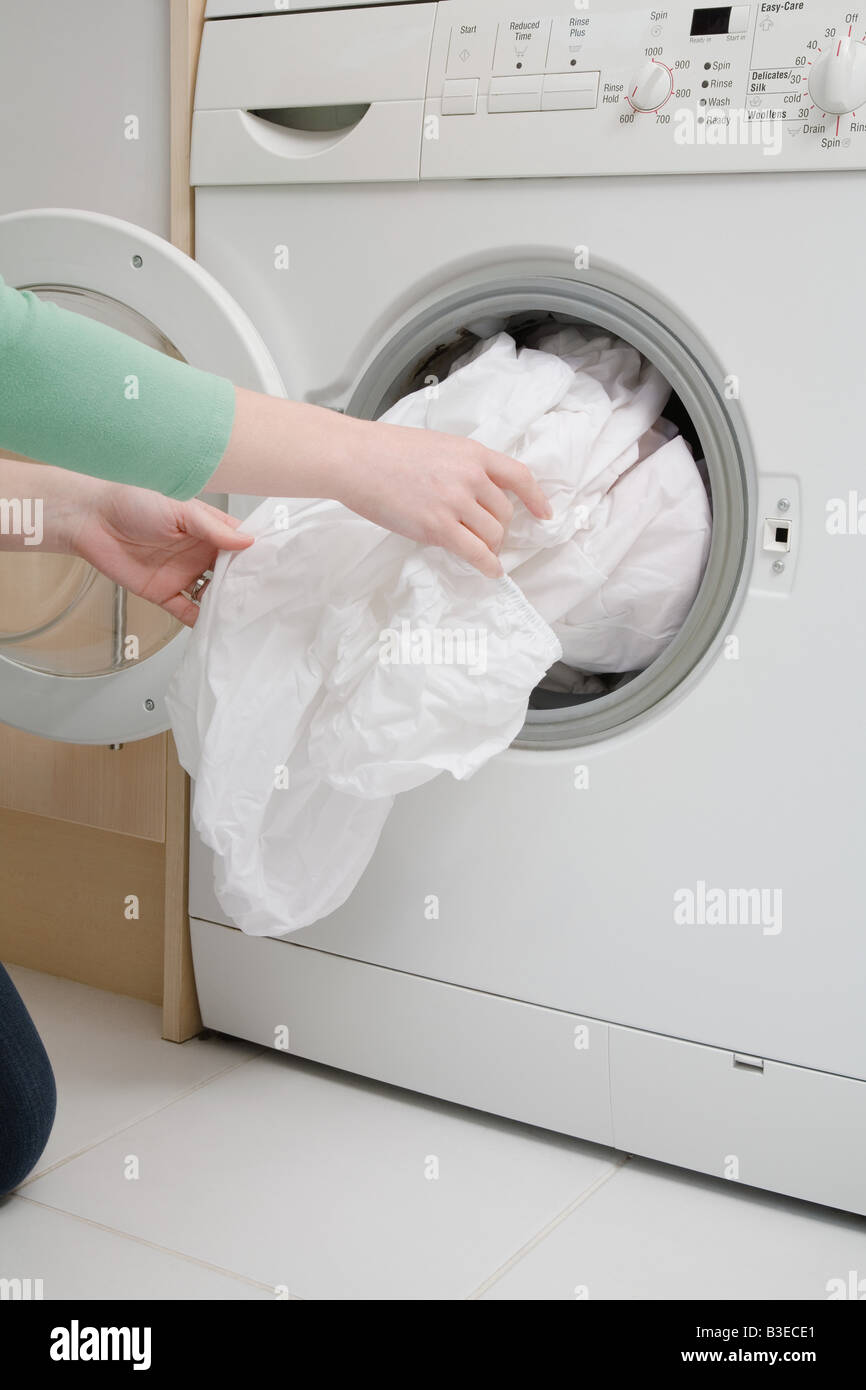 Woman taking sheet from washing machine Stock Photo Alamy