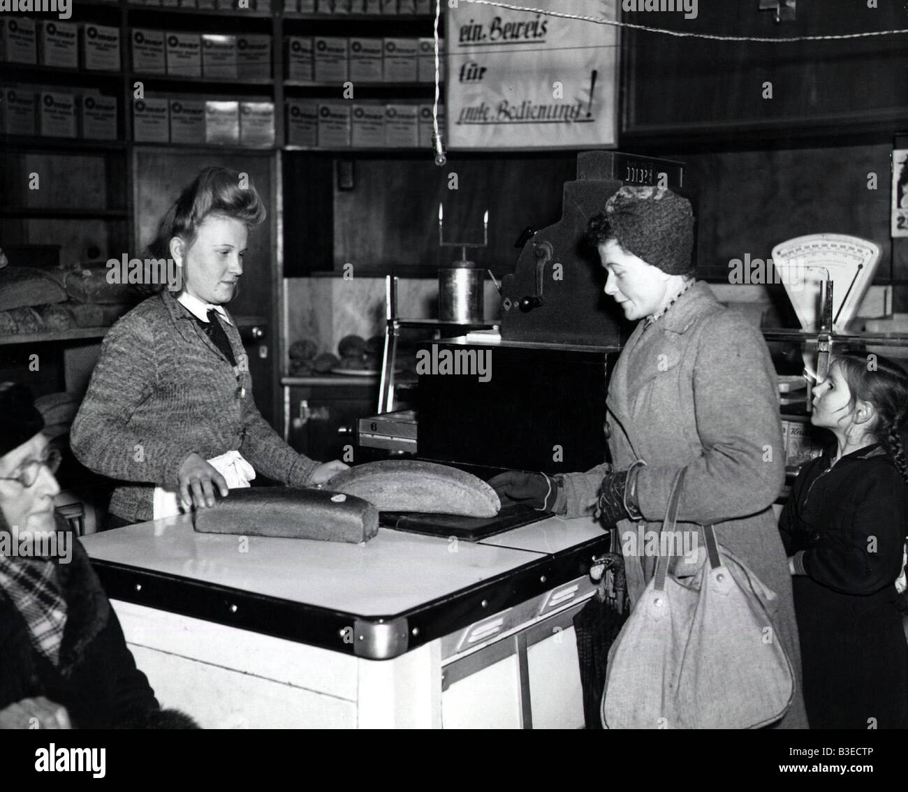 geography / travel, Germany, Berlin, Blockade 1948 / 1949, woman buying bread at a bakery, 24.11.1948, historic, historical, Europe, 1940s, 40s, Berlin-Blockade, postwar period, comestibles, food, selling, corner shop, store, retailing, female, woman, women, people, 20th century, Stock Photo