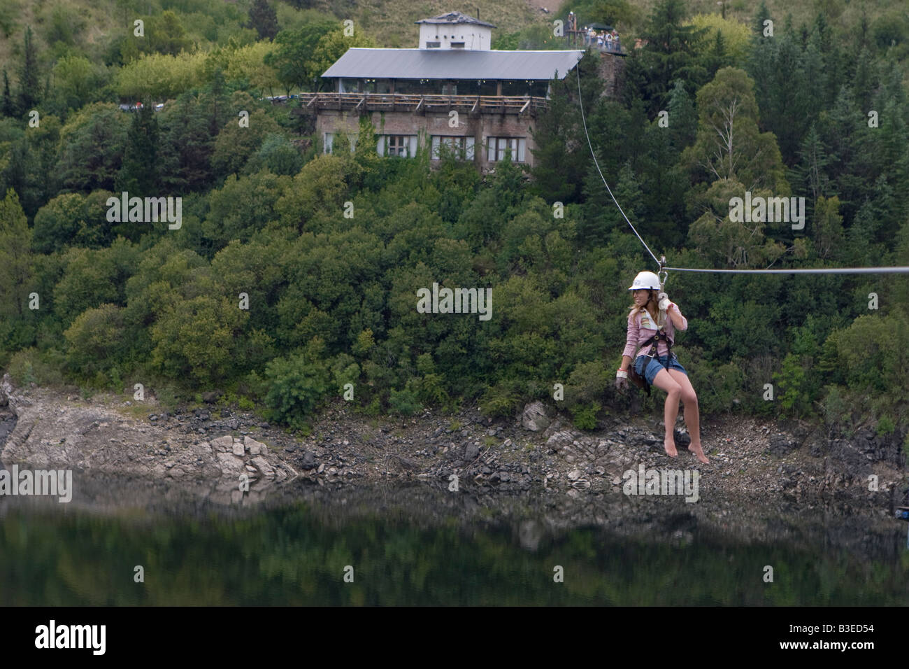 Female tourist doing canopy cable in Dique Los Molinos dam Cordoba ...