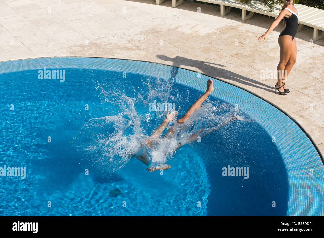 Woman pushing man in a swimming pool Stock Photo Alamy