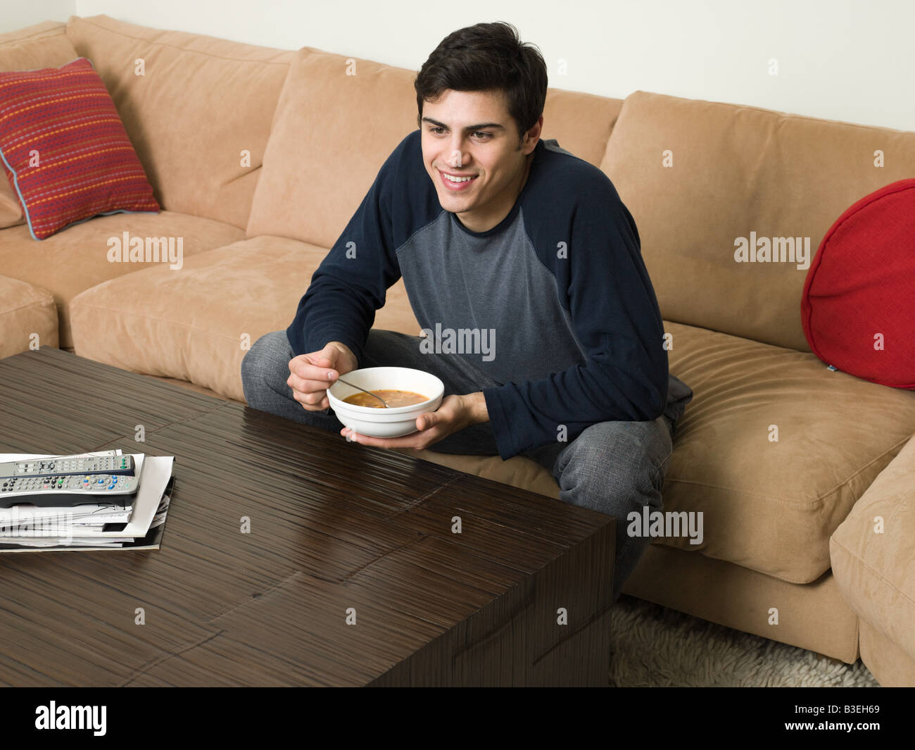 Man on sofa with soup Stock Photo Alamy
