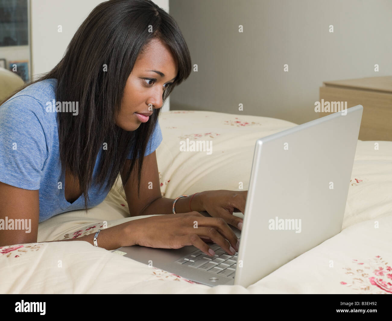Woman on bed with laptop Stock Photo - Alamy
