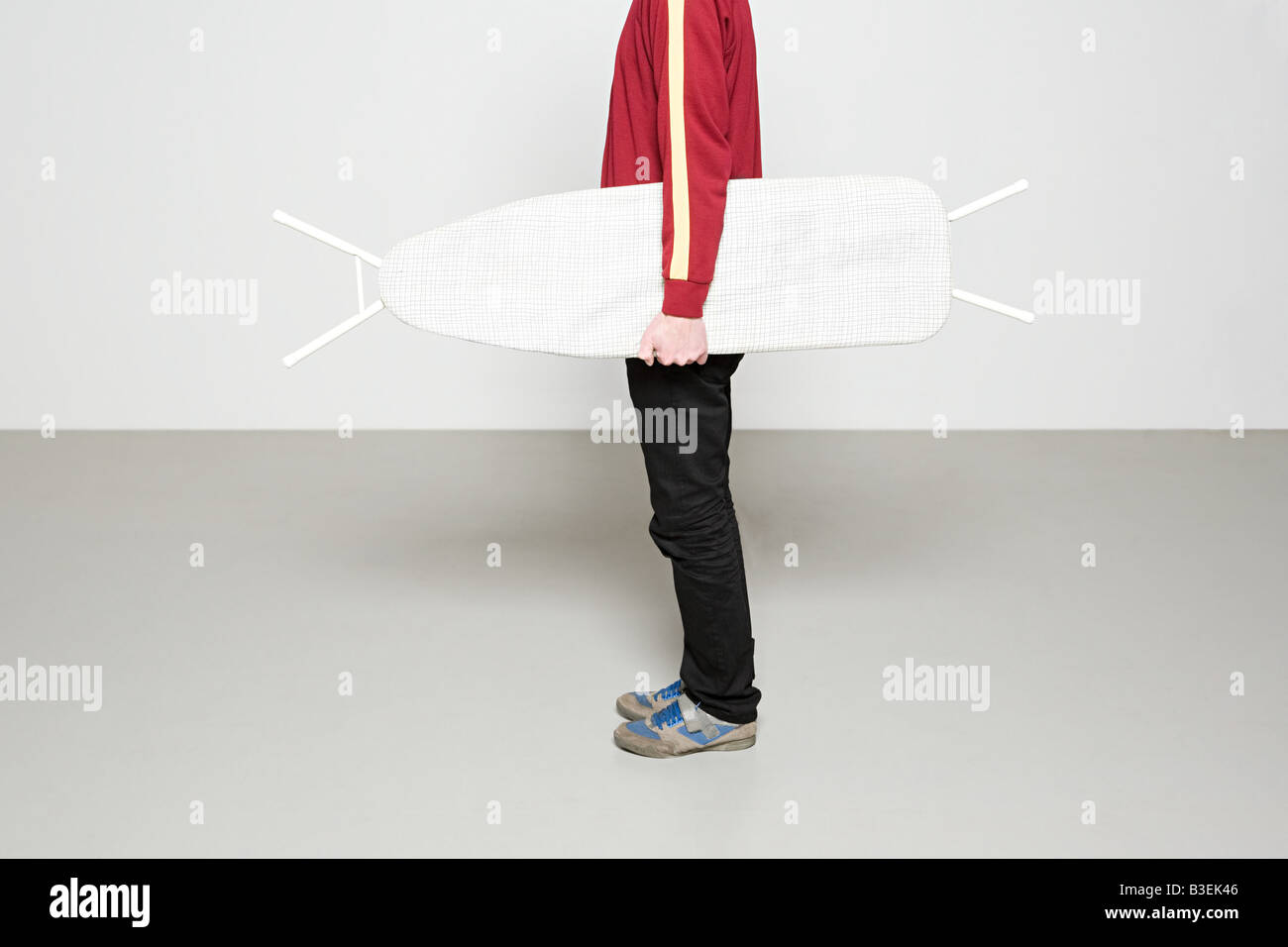 Man holding ironing board like surfboard Stock Photo Alamy