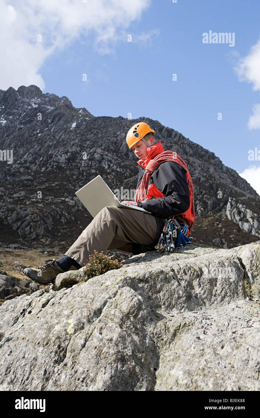 A man using a laptop on a rock Stock Photo