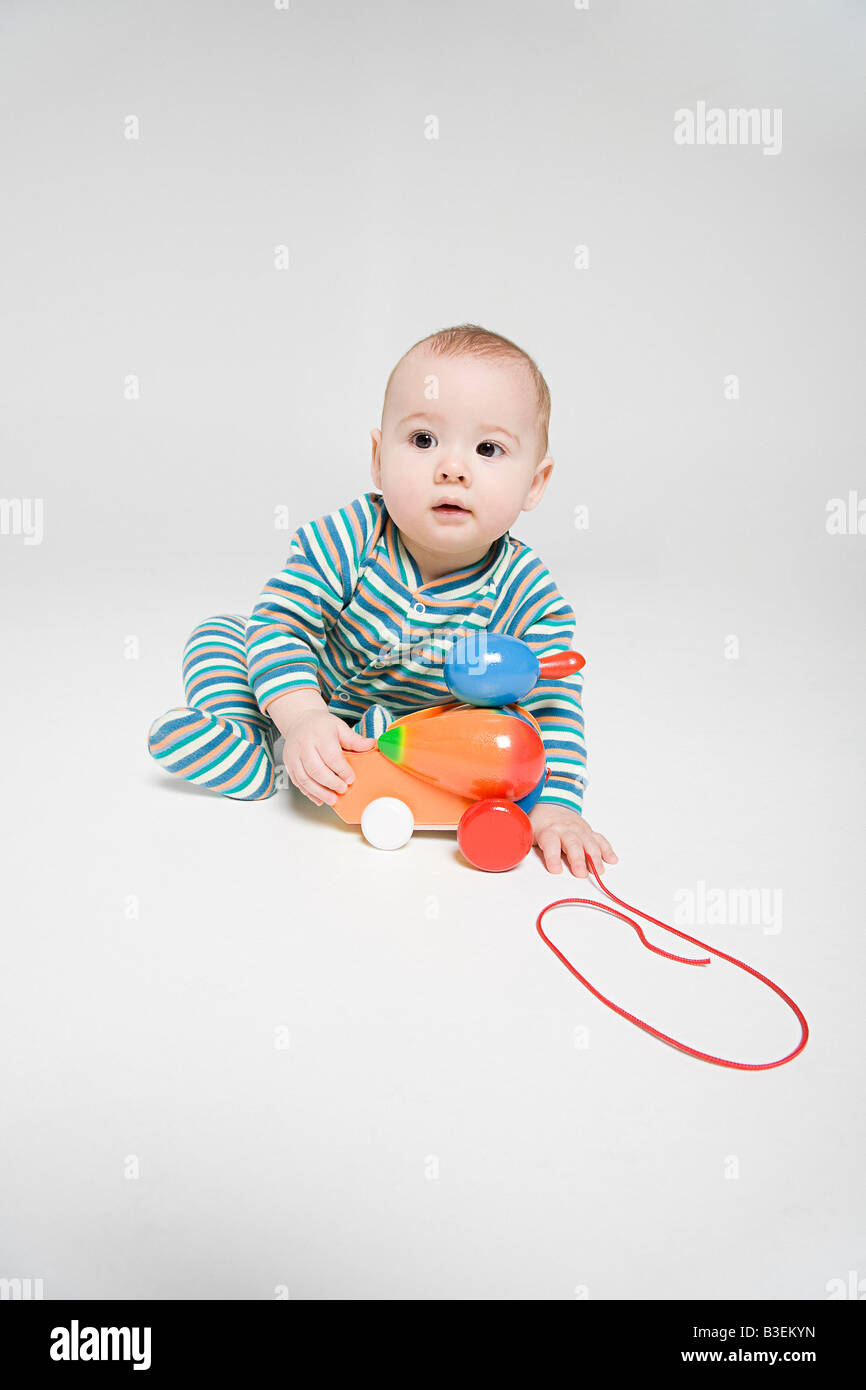 A baby boy playing with a toy Stock Photo - Alamy