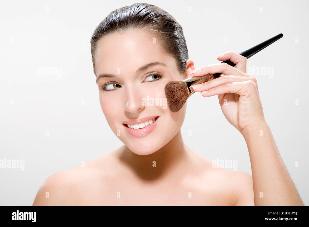 Young woman using make up brush, portrait Stock Photo Alamy