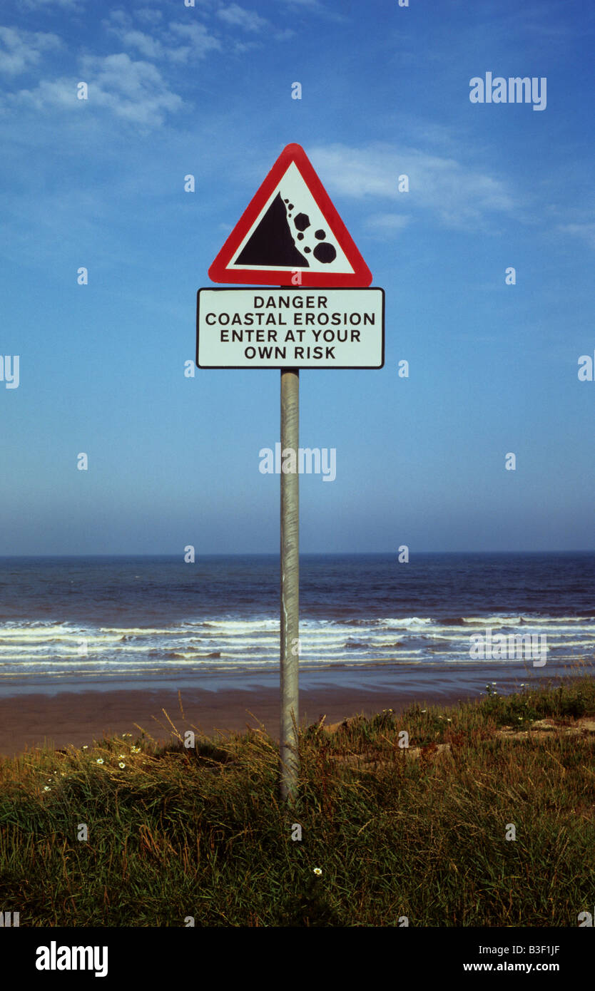 danger warning sign of coastal erosion near Ulrome East coast of Yorkshire UK Stock Photo