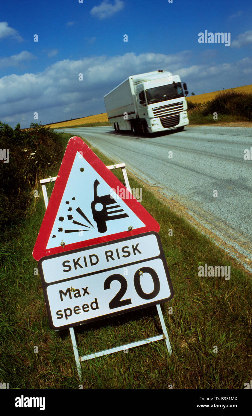 articulated lorry passing warning sign of newly surfaced road and loose chippings near Towton Yorkshire UK Stock Photo