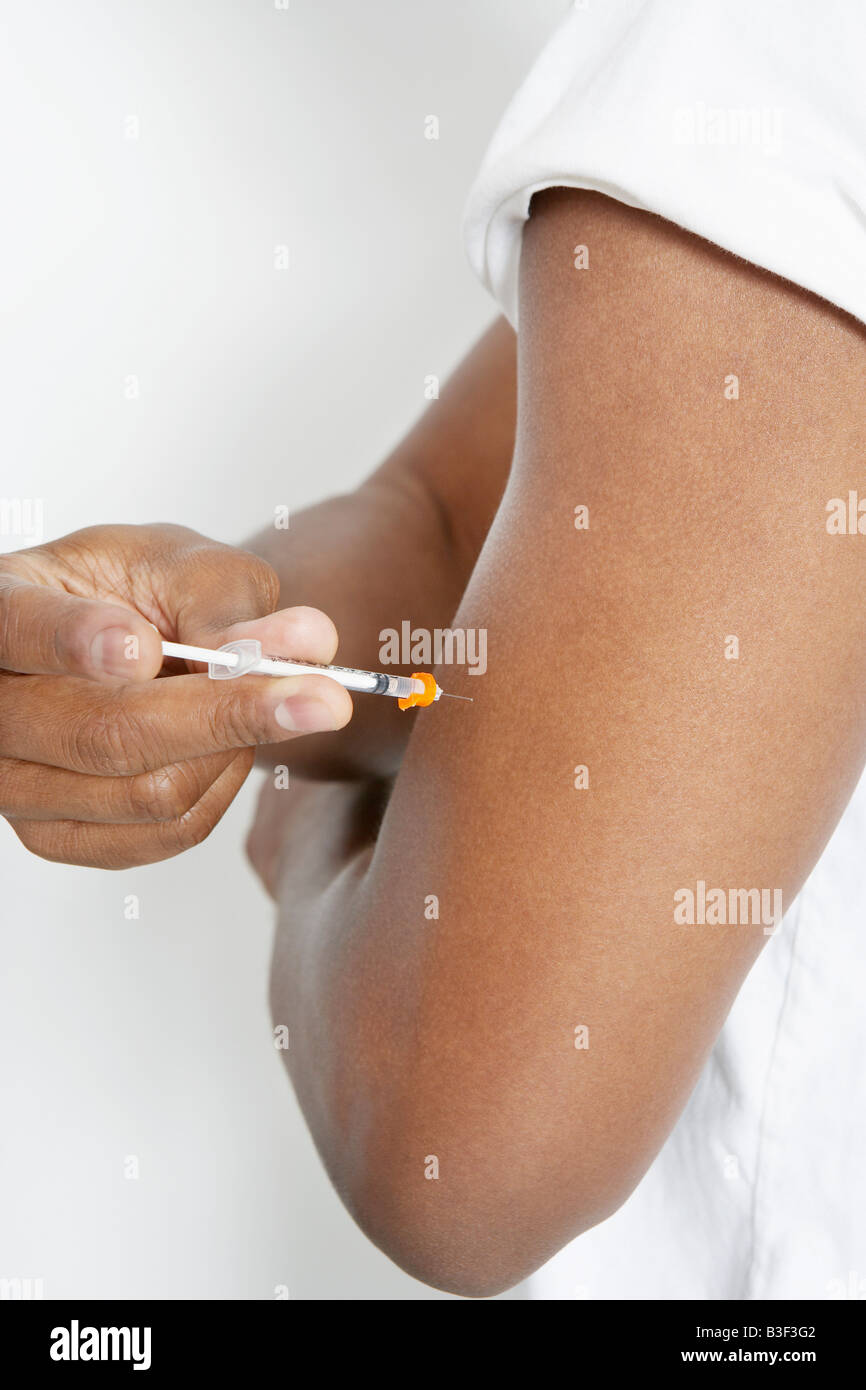 Man injecting insulin using syringe, close-up Stock Photo