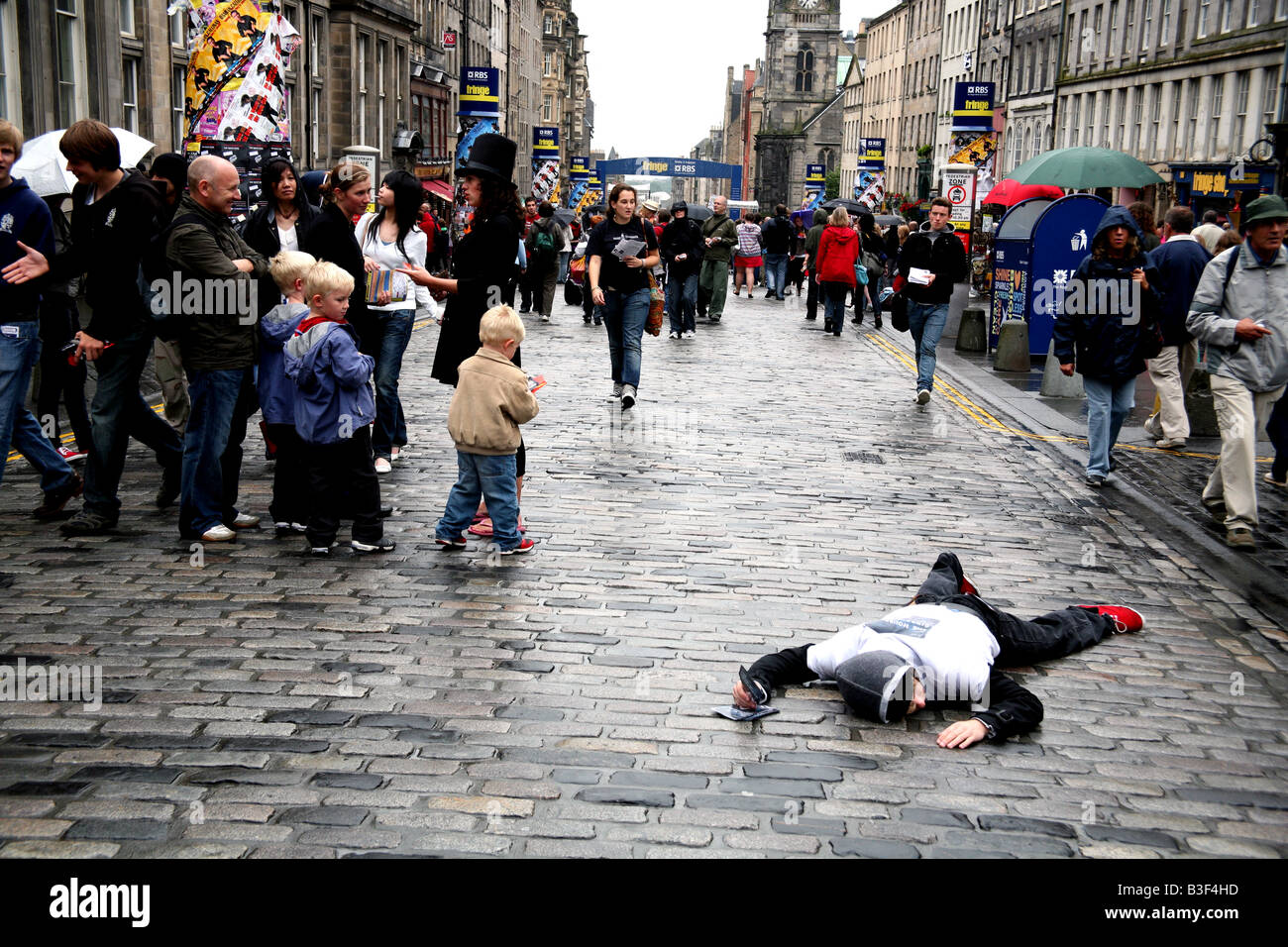 Edinburgh Fringe Festival performer plays dead on the Royal Mile to distribute flyers Stock Photo