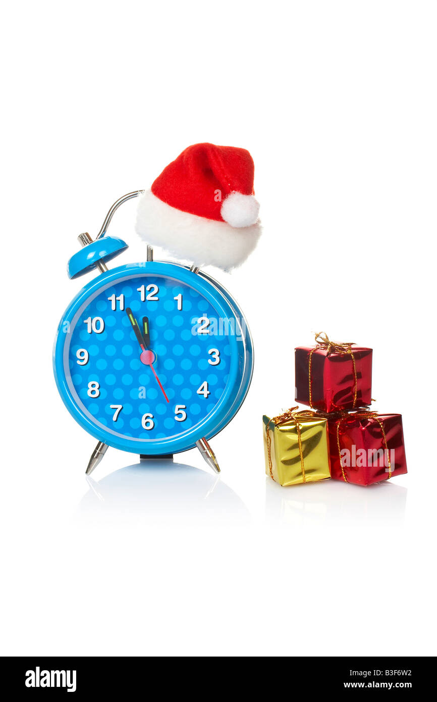 Blue alarm clock with christmas hat and gifts reflected on white background Stock Photo