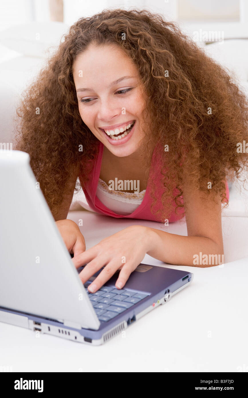 Woman lying in bed with laptop smiling Stock Photo - Alamy