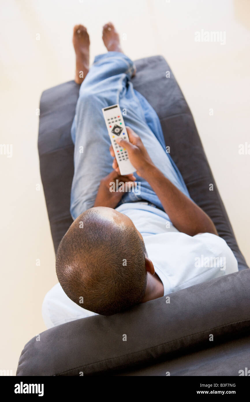 Man sitting in chair using remote control Stock Photo