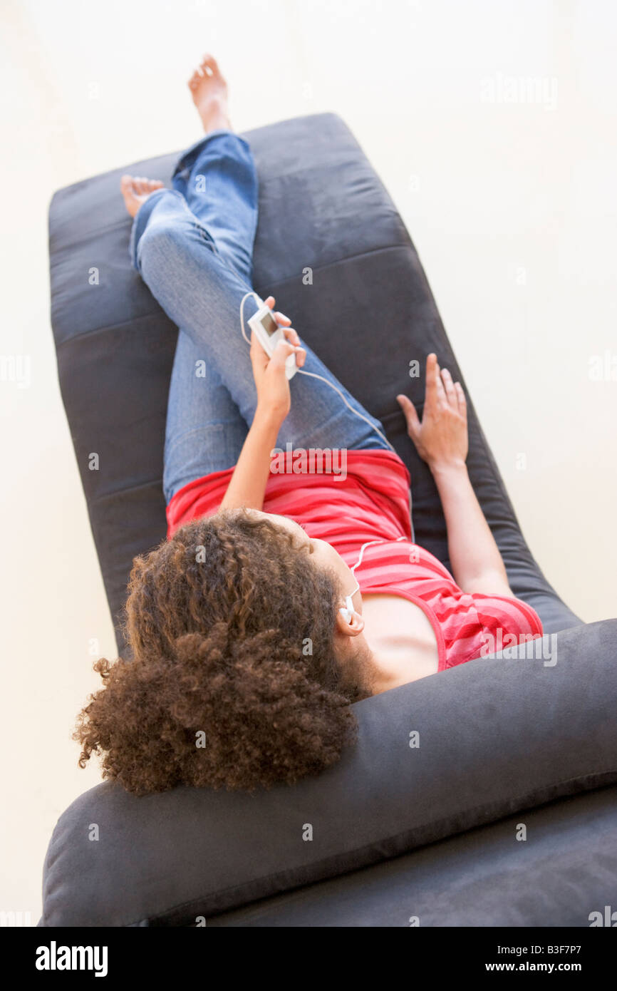 Woman sitting in chair listening to MP3 player Stock Photo