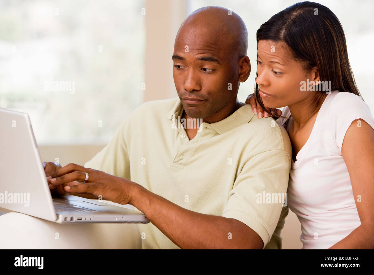 Couple in living room using laptop Stock Photo - Alamy