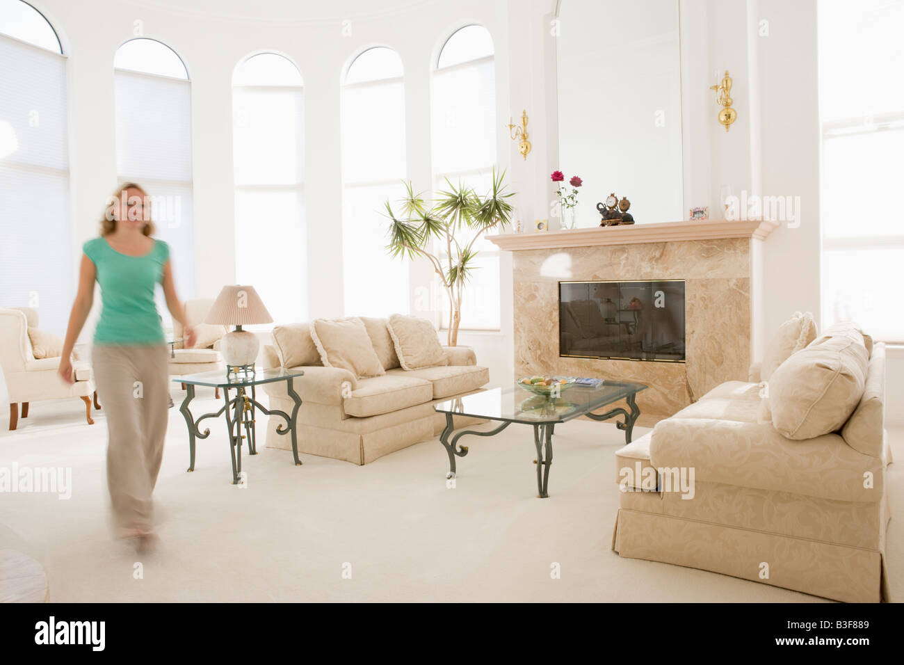 Woman walking through living room Stock Photo Alamy