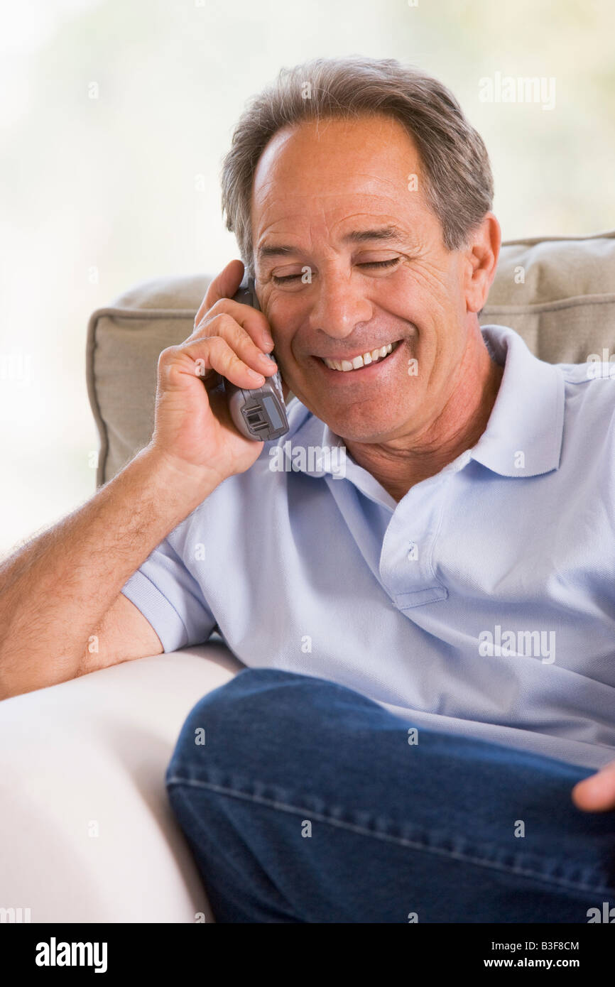 Man indoors using telephone smiling Stock Photo - Alamy