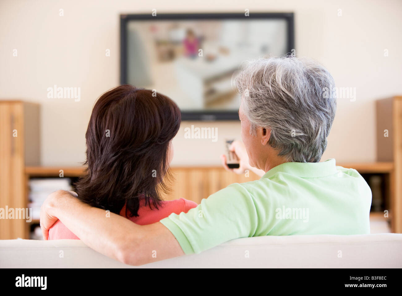 Couple watching television using remote control Stock Photo - Alamy