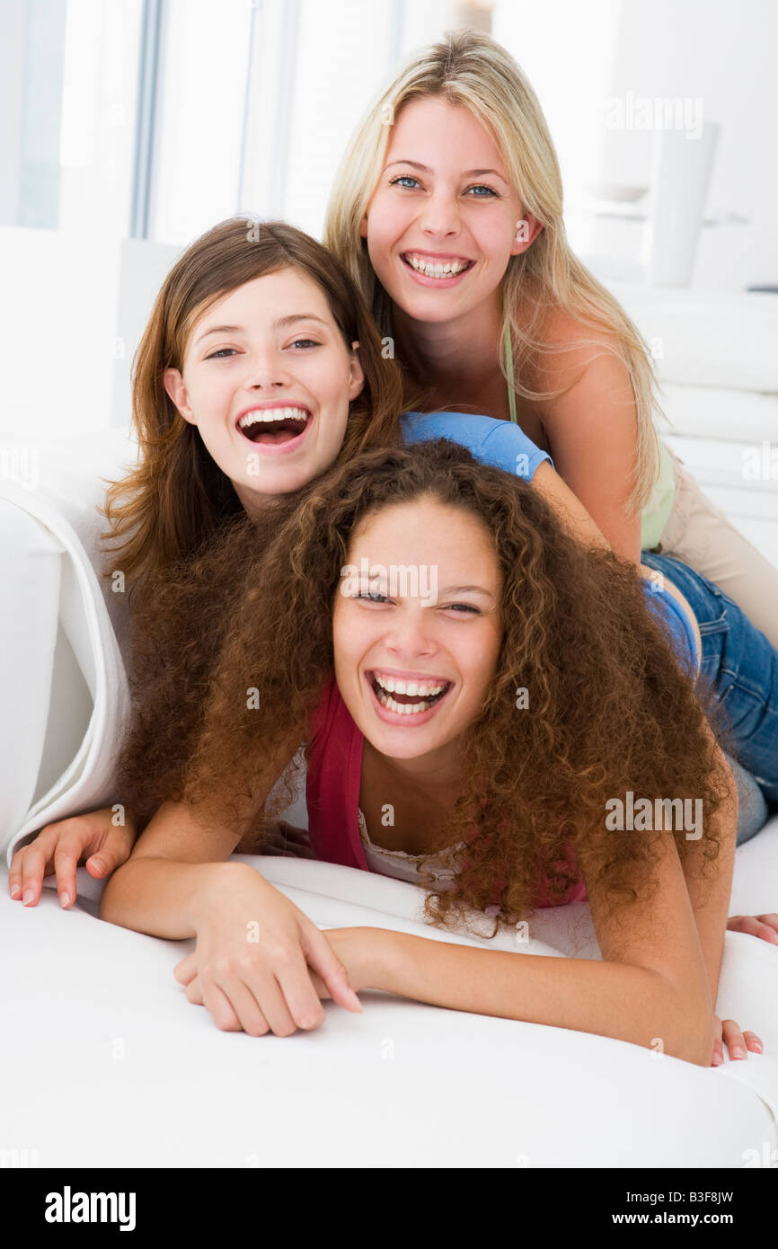Three women in living room playing and smiling Stock Photo