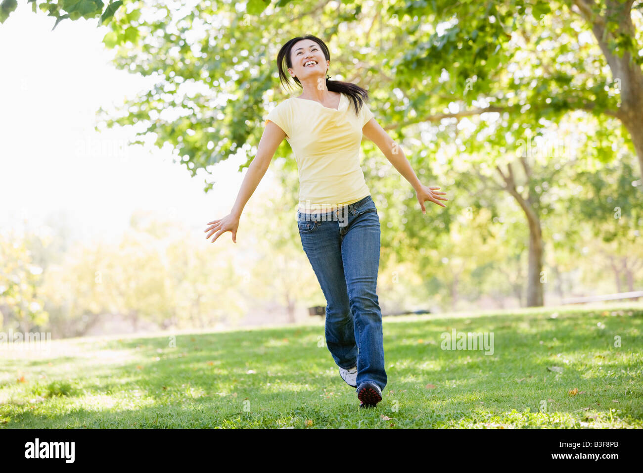 Smiling Running Around Woman running outdoors smiling Stock Photo - Alamy