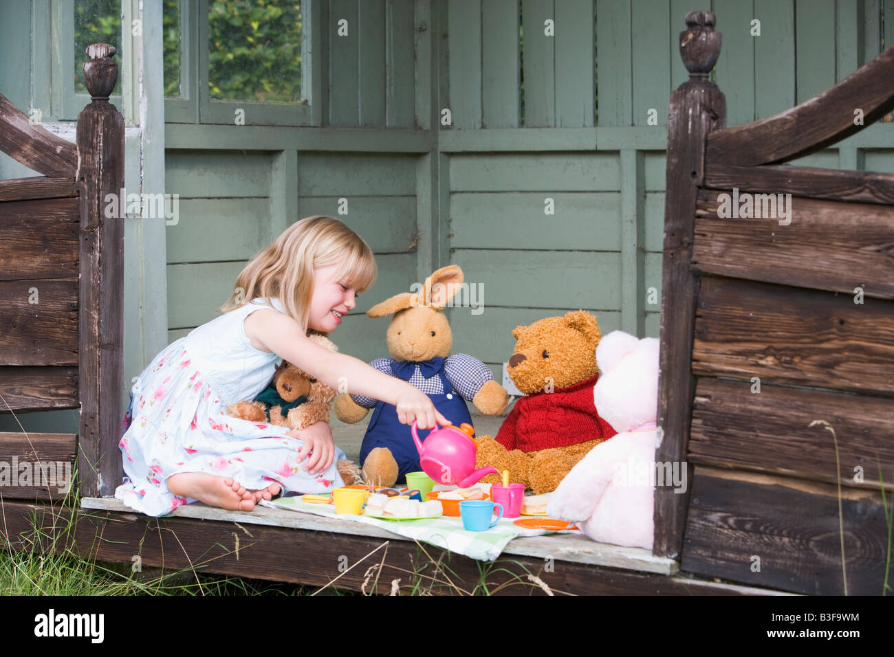 Young girl in shed playing tea and smiling Stock Photo