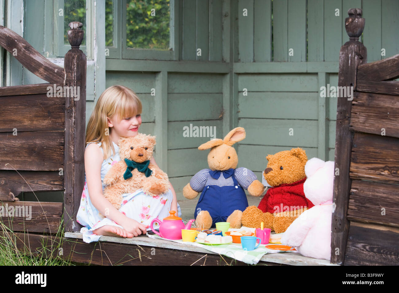 Young girl in shed playing tea and smiling Stock Photo