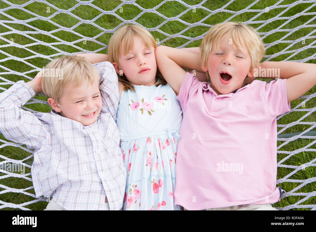 Three children relaxing and sleeping in hammock Stock Photo Alamy