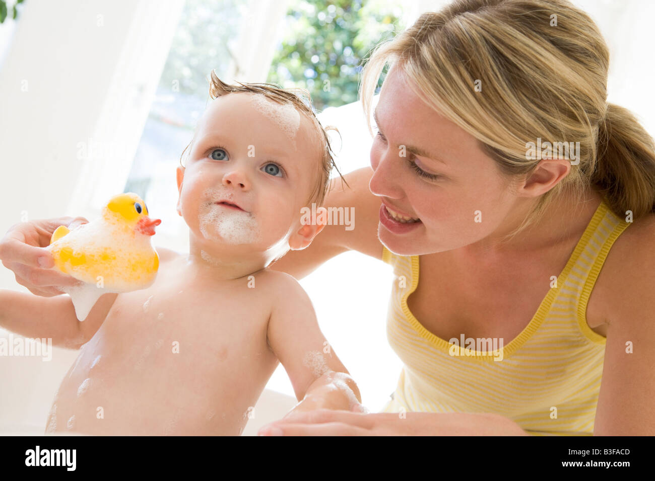 Mother giving baby bubble bath smiling Stock Photo Alamy